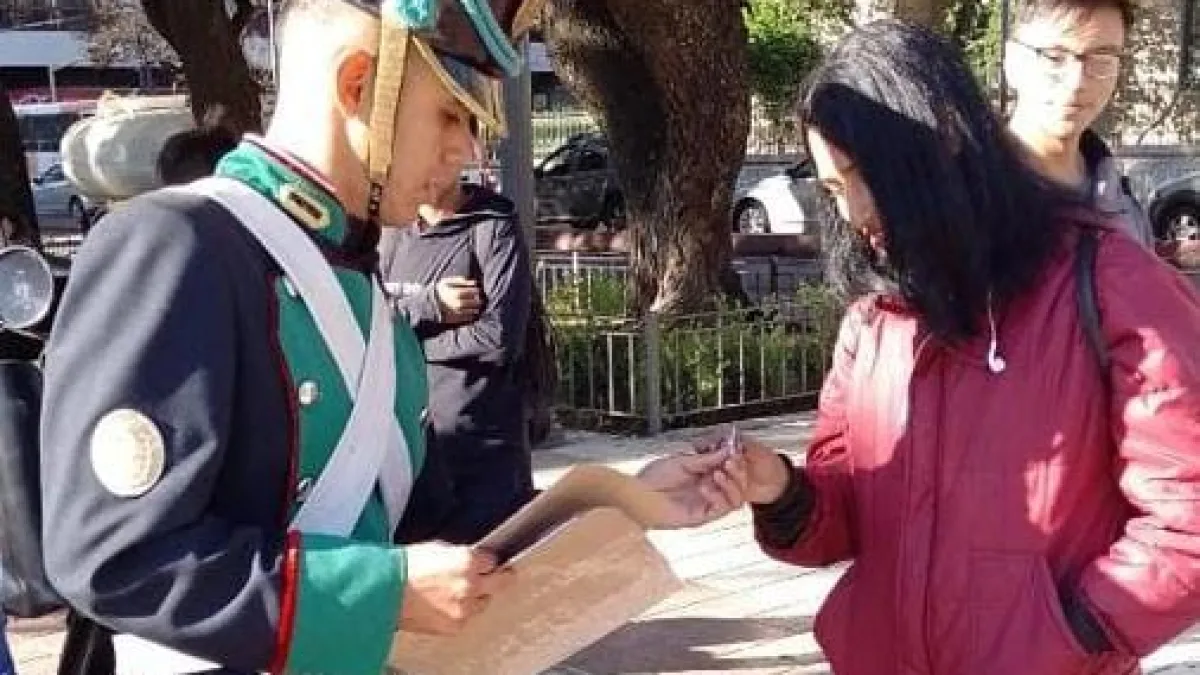 La guardia oficial del Cabildo reparte escarapelas en la plaza Colón